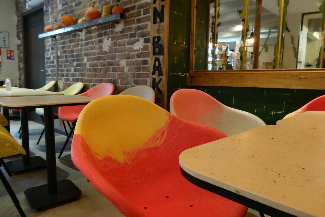 des fauteuils et tables de couleurs dans une boulangerie
