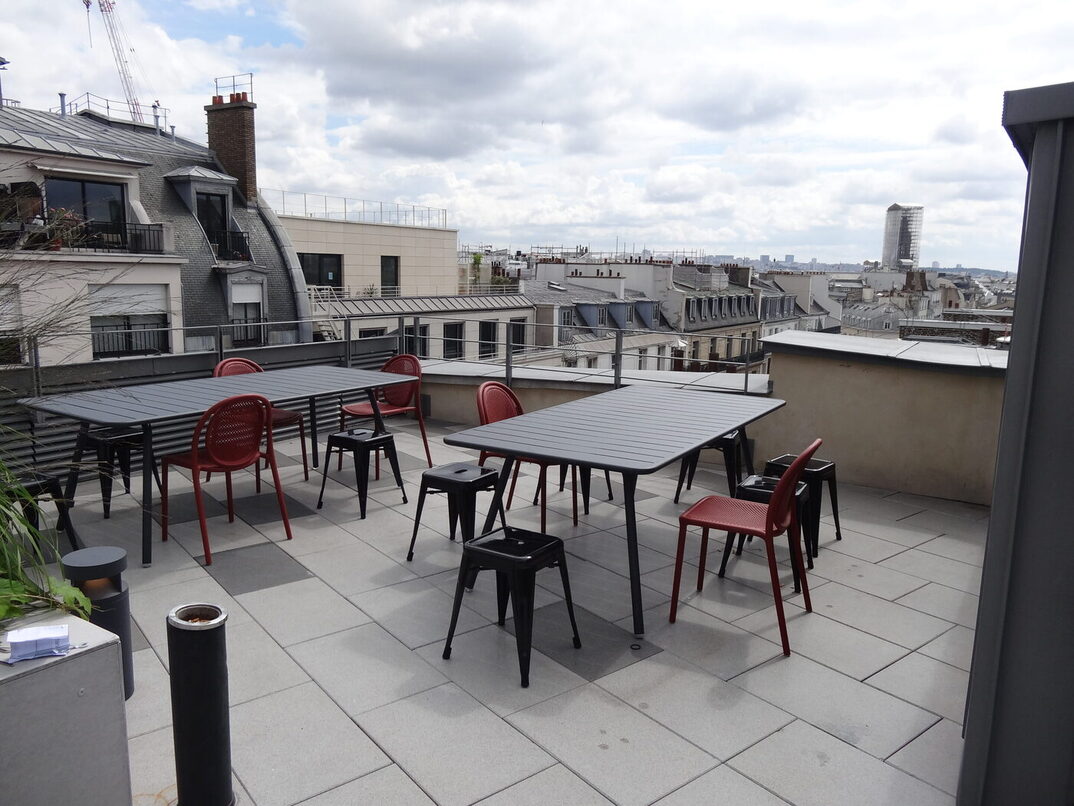 Un rooftop avec des tables et des chaises écoresponsables