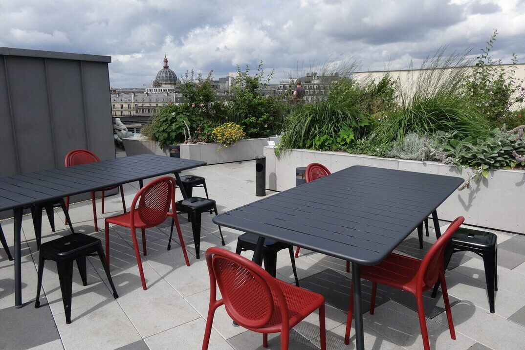 Un rooftop avec des tables et des chaises responsables