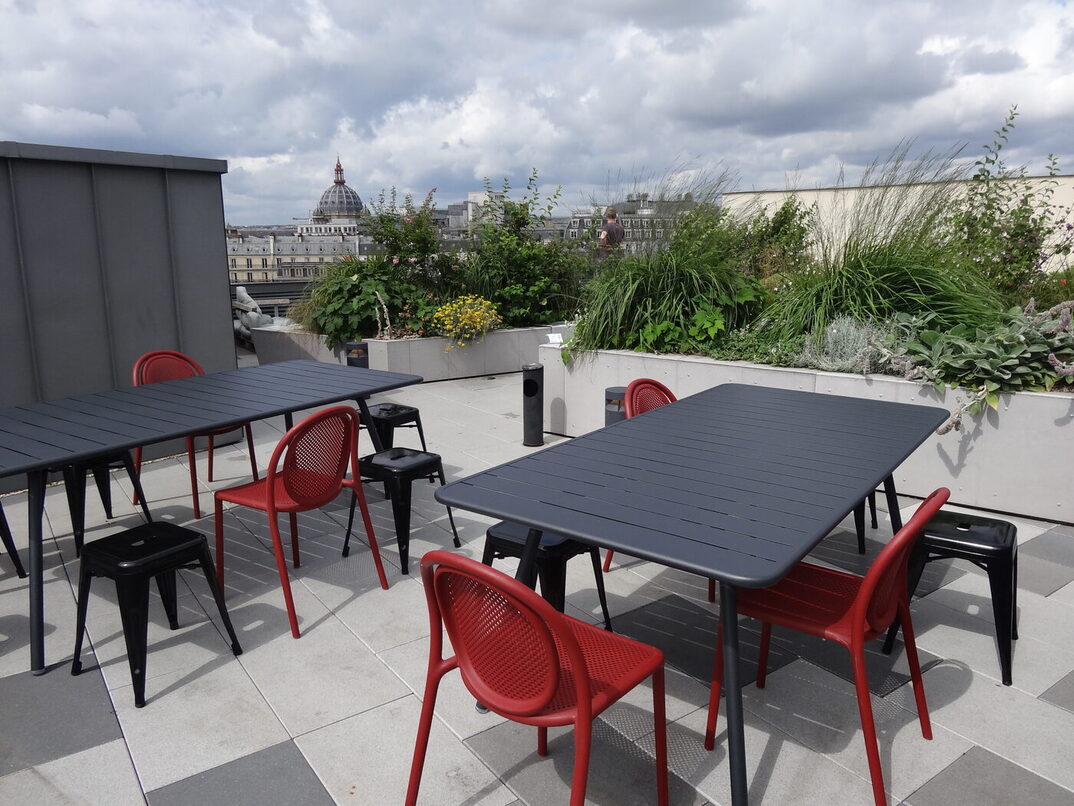 Un rooftop avec des tables et des chaises responsables