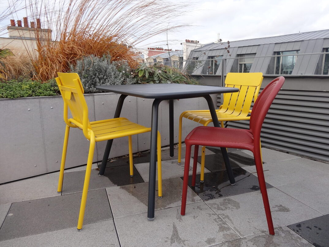 Une table et trois chaises jaunes et rouges