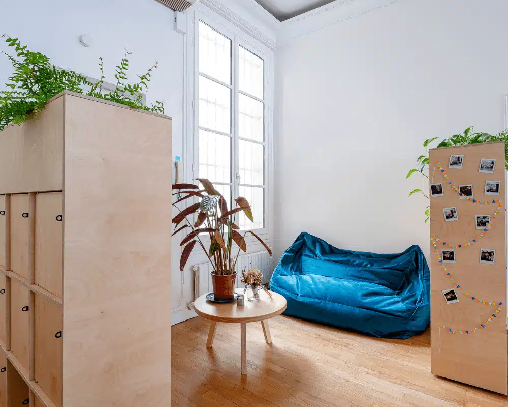 Espace détente en entreprise avec mobilier en bois écoresponsable et pouf bleu confortable