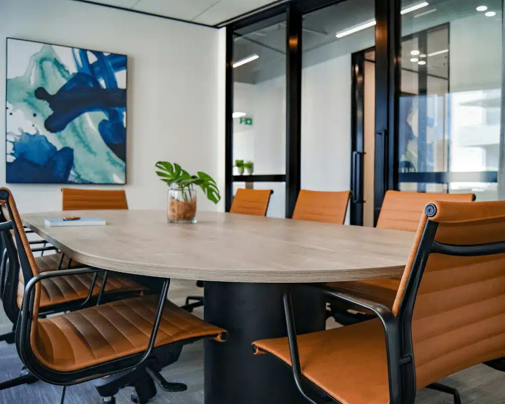 Salle de réunion pour bureau avocat design avec chaises en cuir et table en bois et œuvre d'art.