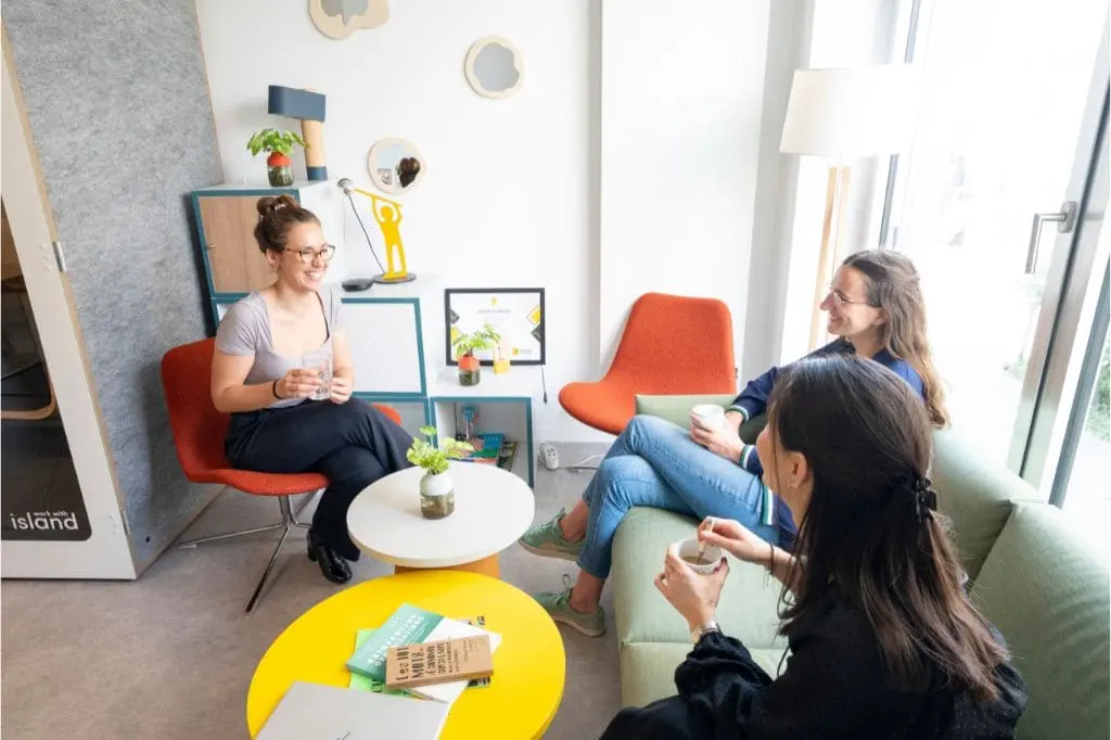 Collègues qui échangent un moment de convivialité au bureau pour la cohésion d'équipe